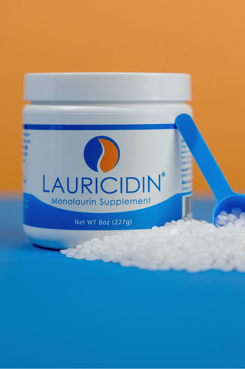 Lauricidin monolaurin supplement container with scoop on a blue and orange background