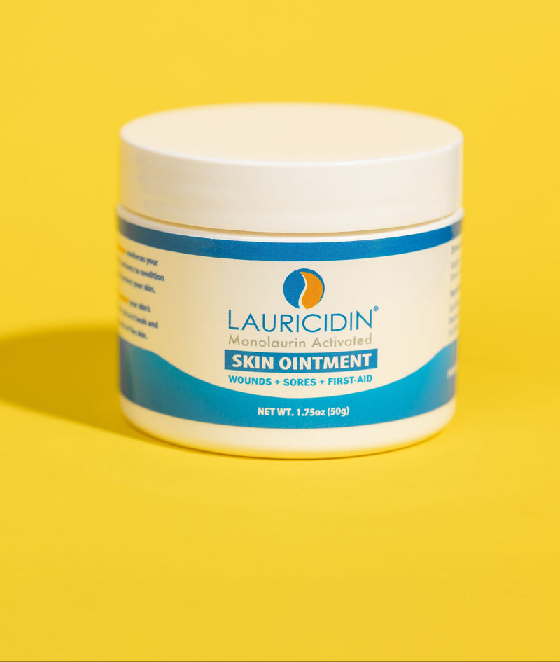 Jar of Lauricidin skin ointment on a yellow background